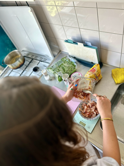 Misja weighing out the exact weight of food so she gets to the same protein amount and calories as in the recipe