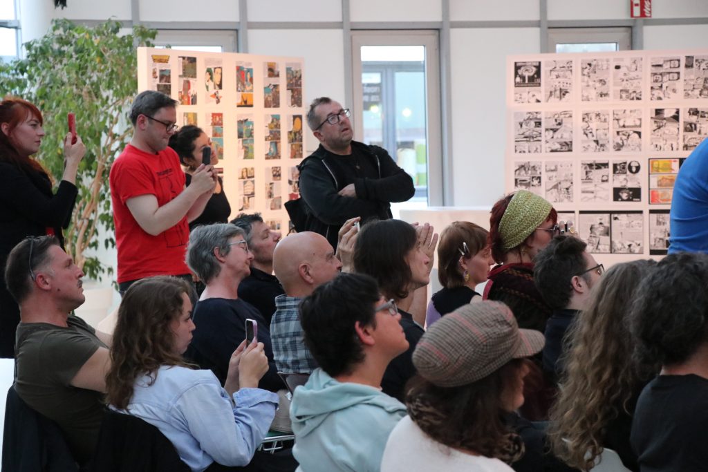 A group of people at an event, all looking ahead.