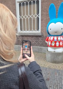 Woman taking a photo of a Nijntje statue outside the Nijntje Museum in Utrecht.