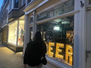 A passerby watching the large neon beer lights