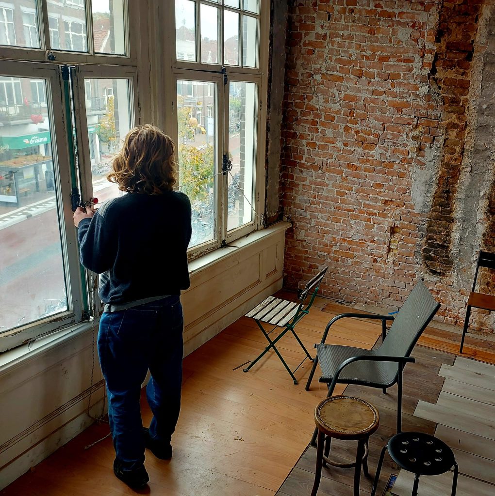 kraker Jos bij het raam in de kamer waar filmavonden worden georganiseerd. Beeld: Vester Schippers.
